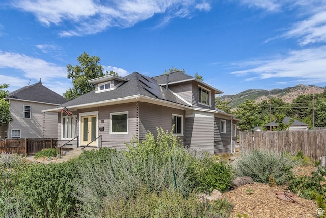 2546 S Fowler, Ogden, UT 84401 - view of front facade featuring solar panels, a mountain view, french doors, and a shingled roof