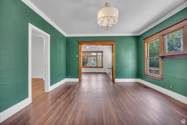 2546 S Fowler, Ogden, UT 84401 - spare room with wood finished floors, a chandelier, crown molding, a textured wall, and a textured ceiling