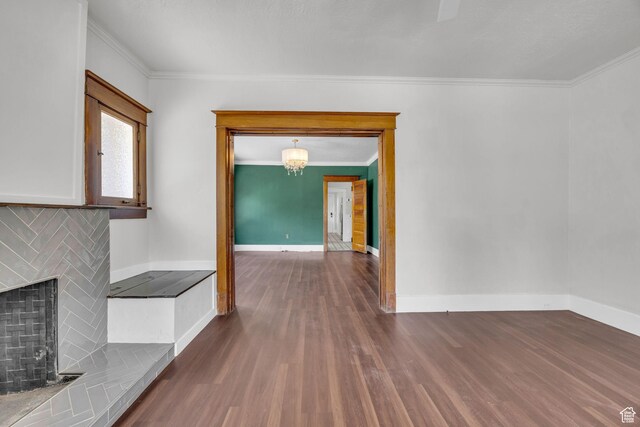 2546 S Fowler, Ogden, UT 84401 - unfurnished living room featuring wood finished floors, crown molding, a fireplace, and a chandelier