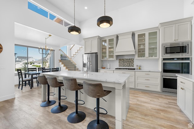 1872 S 250 W, Lehi, UT 84043 - kitchen with premium range hood, stainless steel appliances, a kitchen breakfast bar, an island with sink, and decorative light fixtures