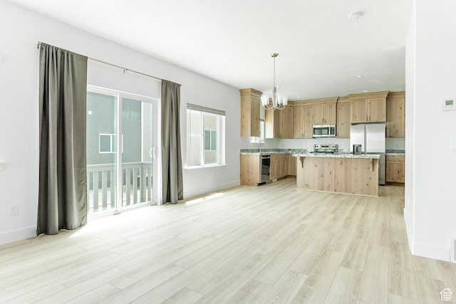 4728 E Lake Corner Dr, Eagle Mountain, UT 84005 - kitchen with appliances with stainless steel finishes, a chandelier, light wood-style floors, pendant lighting, and a kitchen island