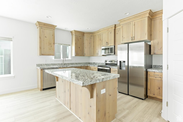 4728 E Lake Corner Dr, Eagle Mountain, UT 84005 - kitchen with stainless steel appliances, light wood-style flooring, light brown cabinetry, a kitchen island, and a breakfast bar area