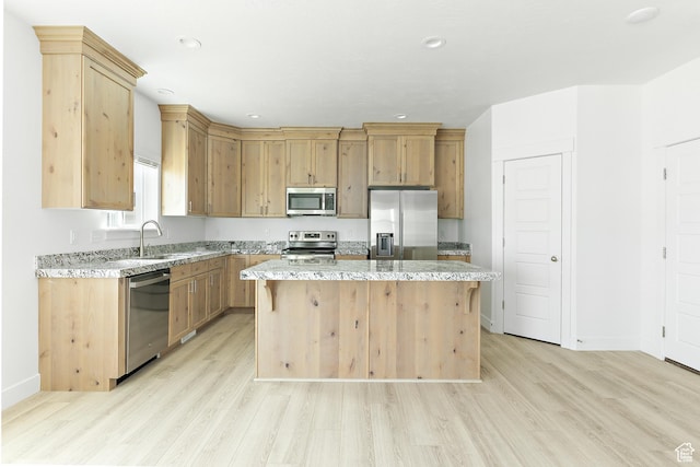 4728 E Lake Corner Dr, Eagle Mountain, UT 84005 - kitchen featuring appliances with stainless steel finishes, light wood-style floors, a kitchen island, light stone countertops, and recessed lighting
