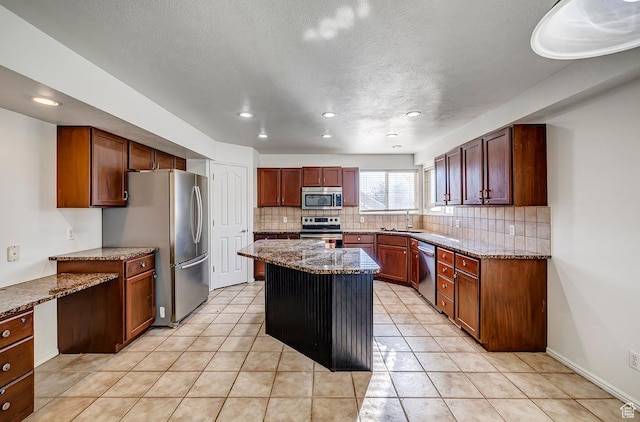 4689 W Nebo Dr S, West Jordan, UT 84088 - kitchen featuring appliances with stainless steel finishes, tasteful backsplash, a kitchen island, recessed lighting, and stone counters