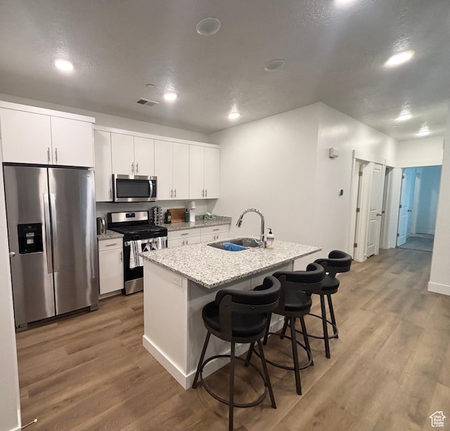460 W 15 S Unit G201, Providence, UT 84332 - kitchen featuring stainless steel appliances, light wood-style flooring, a kitchen bar, white cabinetry, and recessed lighting
