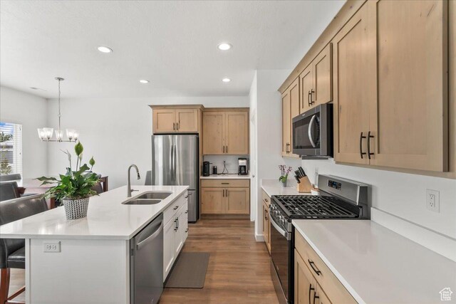 4113 S 3560 W, West Haven, UT 84401 - kitchen featuring appliances with stainless steel finishes, a breakfast bar area, a chandelier, wood finished floors, and light countertops