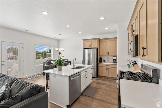 4113 S 3560 W, West Haven, UT 84401 - kitchen with stainless steel appliances, open floor plan, light wood-style flooring, a chandelier, and a kitchen bar
