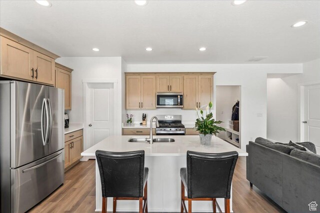 4113 S 3560 W, West Haven, UT 84401 - kitchen featuring appliances with stainless steel finishes, a breakfast bar, light countertops, wood finished floors, and light brown cabinets