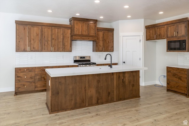 156 N Sherwood Dr, Providence, UT 84332 - kitchen featuring stainless steel range, black microwave, light countertops, an island with sink, and tasteful backsplash