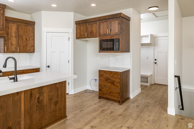 156 N Sherwood Dr, Providence, UT 84332 - kitchen featuring black microwave, light countertops, decorative backsplash, light wood-type flooring, and recessed lighting