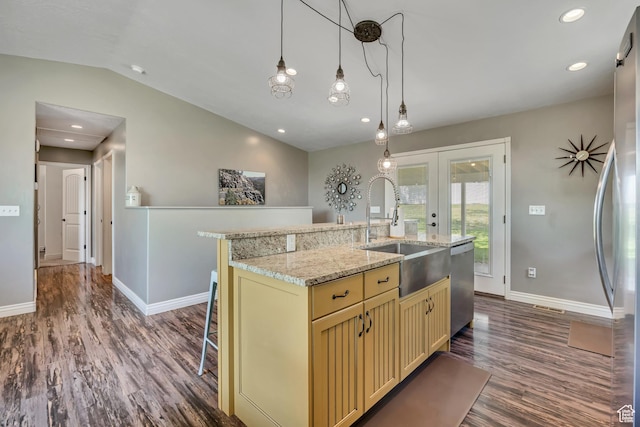 470 Hiland Rd, Ogden, UT 84404 - kitchen with stainless steel appliances, cream cabinetry, dark wood-style floors, vaulted ceiling, and a center island with sink