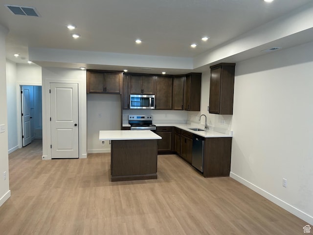 247 E 1825 N Unit 9, North Ogden, UT 84414 - kitchen with stainless steel appliances, dark brown cabinets, light wood-type flooring, a kitchen island, and light countertops