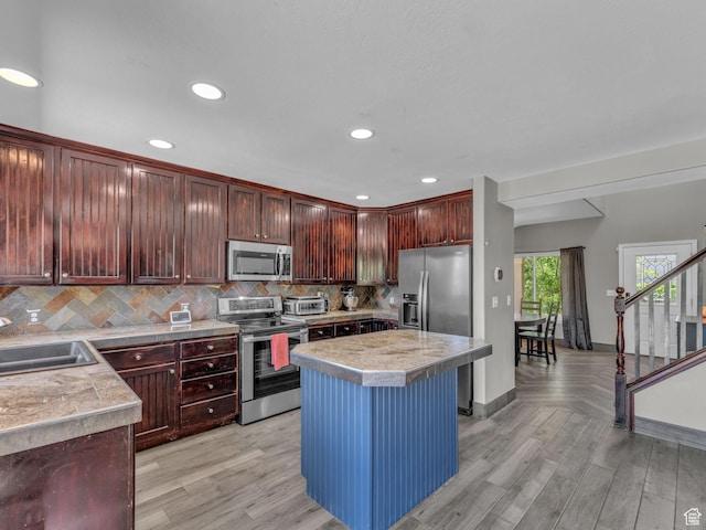 6238 W 8235 S, West Jordan, UT 84084 - kitchen with appliances with stainless steel finishes, tasteful backsplash, recessed lighting, light wood-style flooring, and a center island