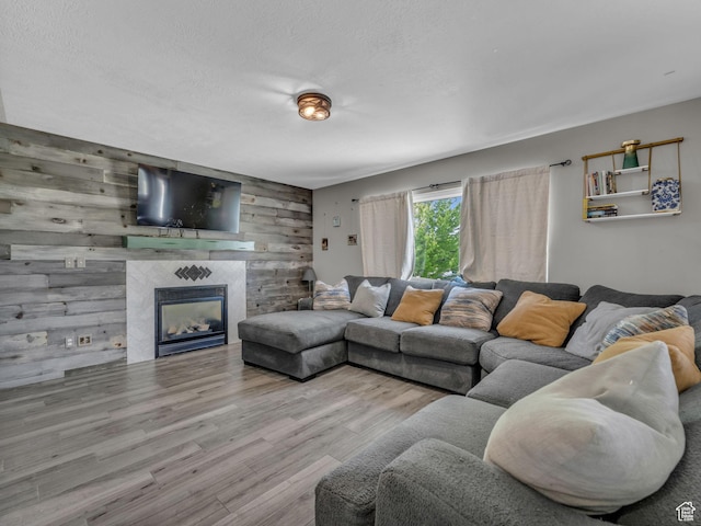 6238 W 8235 S, West Jordan, UT 84084 - living area featuring wooden walls, wood finished floors, a fireplace, an accent wall, and a textured ceiling