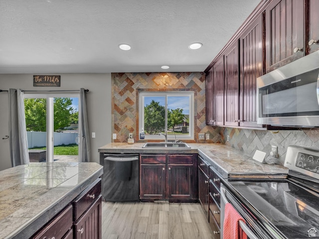 6238 W 8235 S, West Jordan, UT 84084 - kitchen with appliances with stainless steel finishes, backsplash, recessed lighting, light wood finished floors, and a textured ceiling
