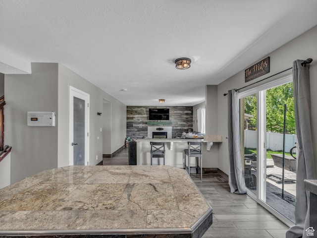 6238 W 8235 S, West Jordan, UT 84084 - kitchen featuring tile counters, a fireplace, wood finished floors, and a textured ceiling