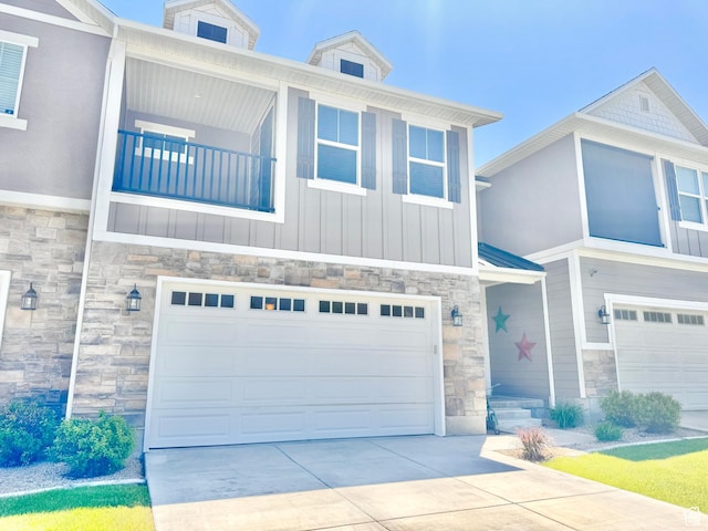 5923 W 8170 S Unit U102, West Jordan, UT 84081 - view of front of property with stone siding, an attached garage, concrete driveway, and board and batten siding
