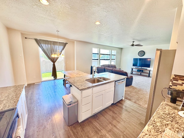 5923 W 8170 S Unit U102, West Jordan, UT 84081 - kitchen featuring stainless steel appliances, open floor plan, a textured ceiling, white cabinetry, and wood finished floors