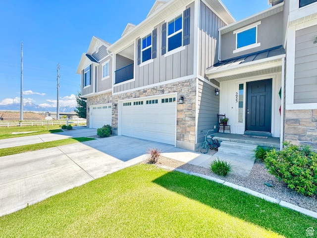 5923 W 8170 S Unit U102, West Jordan, UT 84081 - view of front of house with a garage, board and batten siding, stone siding, driveway, and a standing seam roof