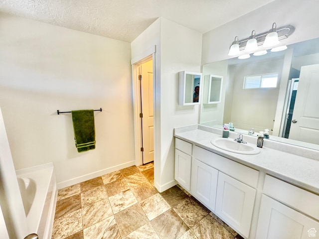 5923 W 8170 S Unit U102, West Jordan, UT 84081 - bathroom featuring vanity, a bath, stone finish floors, and a textured ceiling