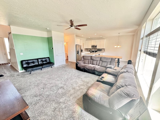 5923 W 8170 S Unit U102, West Jordan, UT 84081 - living room with a textured ceiling, light colored carpet, ceiling fan, and a chandelier