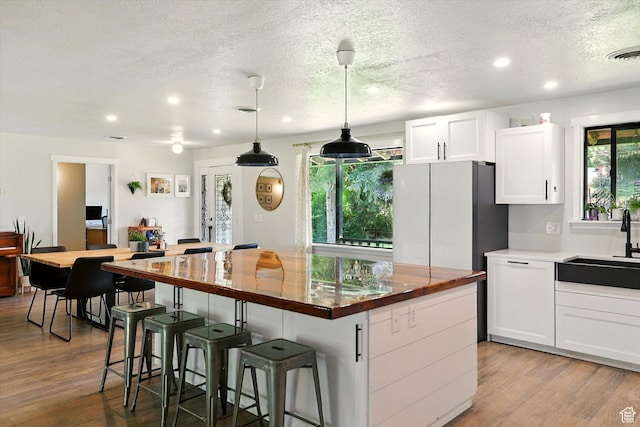 12800 N 1200 E, Cove, UT 84320 - kitchen featuring wood counters, recessed lighting, a textured ceiling, wood finished floors, and white cabinets