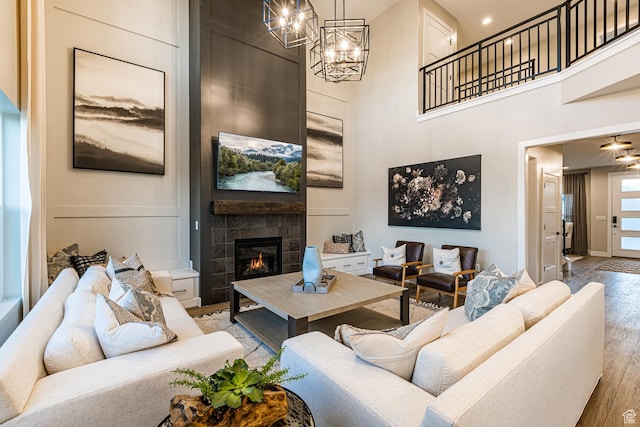 3539 E 1120 E Unit 110, Spanish Fork, UT 84660 - living room featuring light wood finished floors, a fireplace, a high ceiling, and a chandelier