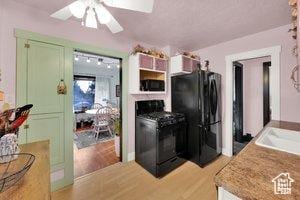 3022 S Jackson Ave E, Ogden, UT 84403 - kitchen featuring black appliances, a ceiling fan, green cabinetry, light wood finished floors, and light countertops