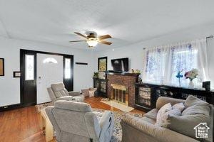 3022 S Jackson Ave E, Ogden, UT 84403 - living room featuring a ceiling fan, wood finished floors, and a brick fireplace