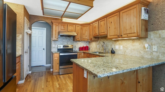 4111 S John Way W, West Valley City, UT 84120 - kitchen featuring stainless steel appliances, under cabinet range hood, light wood-style floors, light stone counters, and a peninsula