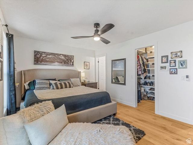 9714 S Buttonwood Dr E, Sandy, UT 84092 - bedroom featuring a spacious closet, light wood-style floors, a ceiling fan, and a closet