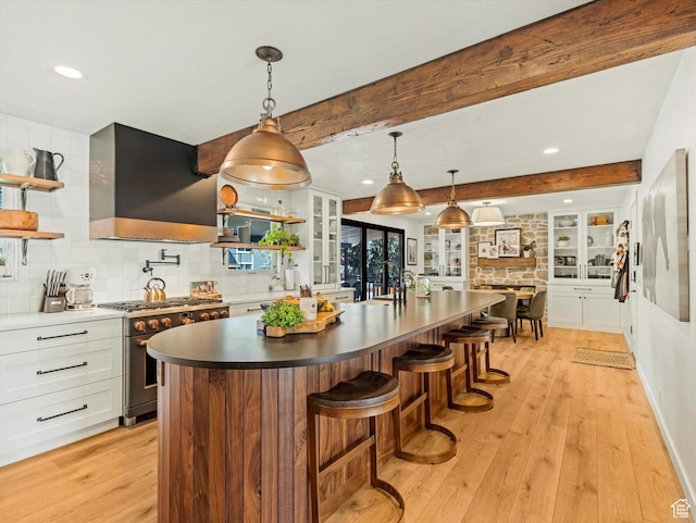 9714 S Buttonwood Dr E, Sandy, UT 84092 - kitchen featuring stainless steel gas range, wall chimney exhaust hood, open shelves, light wood finished floors, and beam ceiling