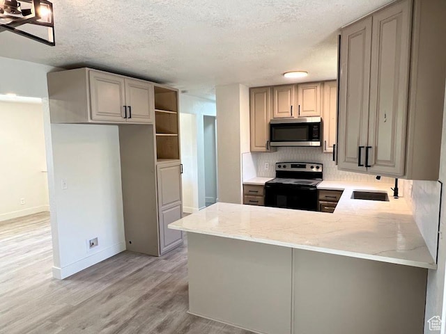 1569 E Boysenberry Cir S, Sandy, UT 84093 - kitchen featuring range with electric cooktop, stainless steel microwave, light wood-type flooring, light stone countertops, and backsplash