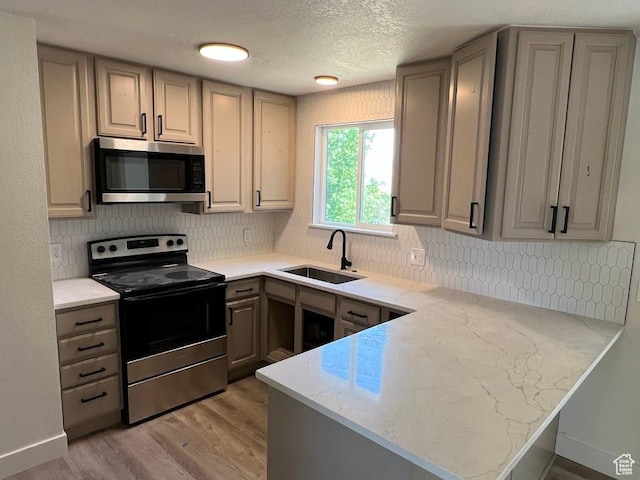 1569 E Boysenberry Cir S, Sandy, UT 84093 - kitchen with appliances with stainless steel finishes, a peninsula, gray cabinetry, light wood-style flooring, and backsplash