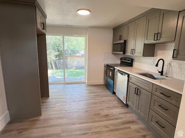 1569 E Boysenberry Cir S, Sandy, UT 84093 - kitchen with stainless steel microwave, dishwasher, electric range, tasteful backsplash, and light wood finished floors