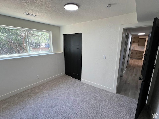 1569 E Boysenberry Cir S, Sandy, UT 84093 - unfurnished bedroom featuring a textured ceiling, carpet floors, and a closet