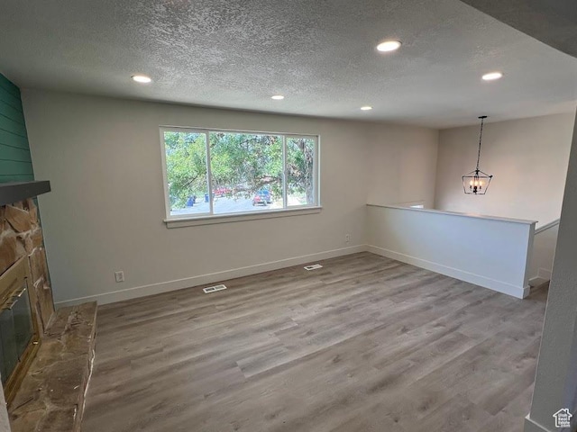 1569 E Boysenberry Cir S, Sandy, UT 84093 - unfurnished living room with recessed lighting, a fireplace, a textured ceiling, wood finished floors, and a chandelier