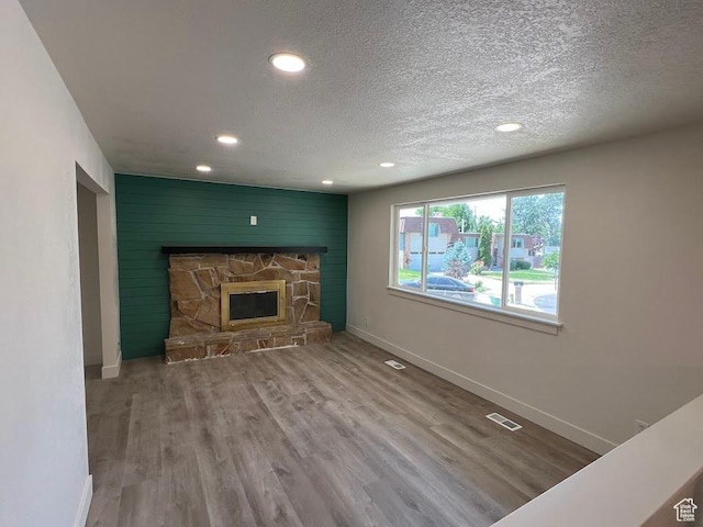 1569 E Boysenberry Cir S, Sandy, UT 84093 - unfurnished living room featuring recessed lighting, wood finished floors, a textured ceiling, and a stone fireplace