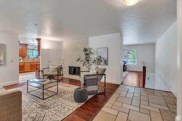 12012 S Hidden Valley Club Dr, Sandy, UT 84092 - living room with a stone fireplace and light wood-style flooring