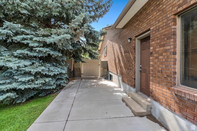 12012 S Hidden Valley Club Dr, Sandy, UT 84092 - view of side of property with brick siding, entry steps, a gate, and a patio area