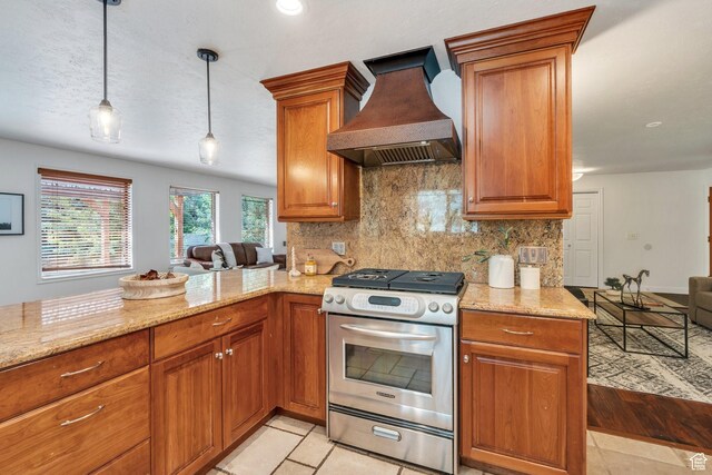 12012 S Hidden Valley Club Dr, Sandy, UT 84092 - kitchen featuring custom range hood, stainless steel gas range oven, brown cabinetry, decorative backsplash, and light stone countertops