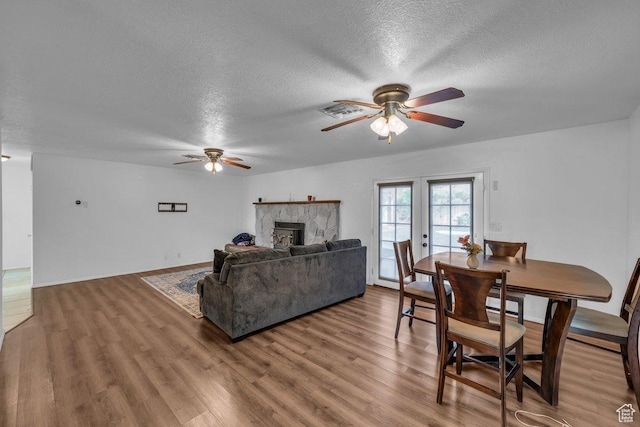 726 N Valley View Dr E, St George, UT 84770 - living room featuring ceiling fan, a textured ceiling, wood finished floors, and a fireplace