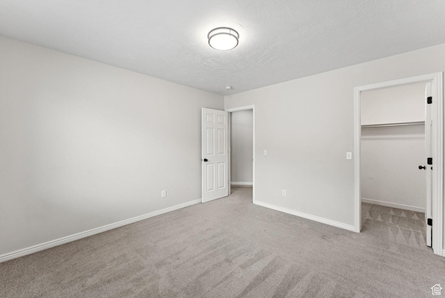 1212 Pinehurst Cir, Farmington, UT 84025 - unfurnished bedroom featuring carpet floors, a walk in closet, a textured ceiling, and a closet