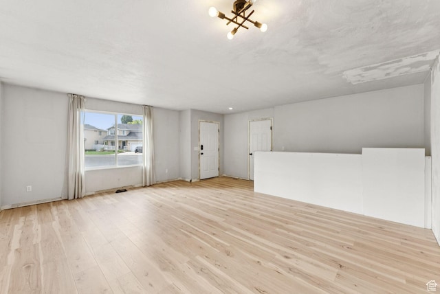 1212 Pinehurst Cir, Farmington, UT 84025 - unfurnished living room featuring light wood-type flooring and a chandelier