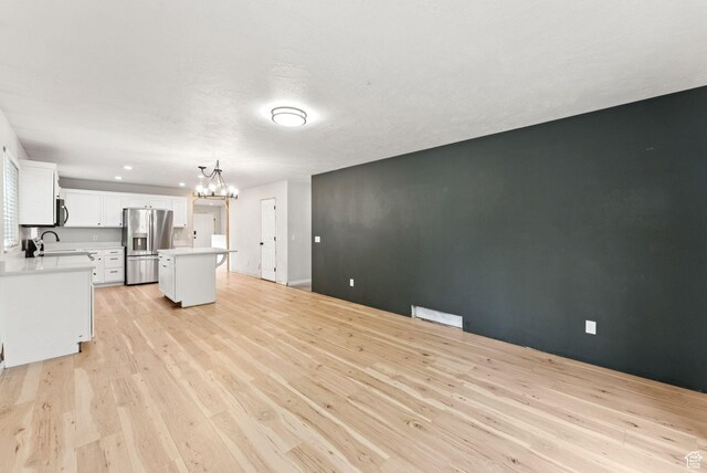 1212 Pinehurst Cir, Farmington, UT 84025 - unfurnished living room with a chandelier and light wood finished floors