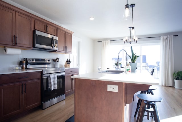 922 Olson Dr N, Saratoga Springs, UT 84045 - kitchen featuring stainless steel appliances, light wood-style floors, a breakfast bar area, light countertops, and recessed lighting
