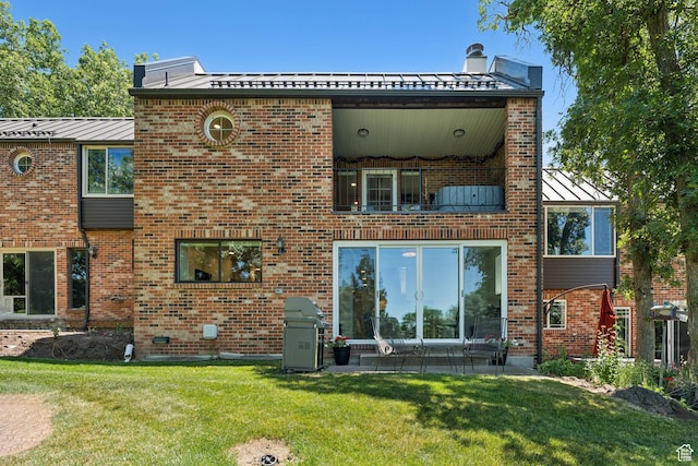 1537 N Sweetwater Ln, Farmington, UT 84025 - back of property featuring a standing seam roof, a yard, brick siding, a patio, and a balcony
