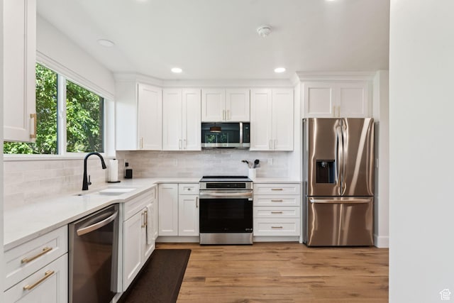 1537 N Sweetwater Ln, Farmington, UT 84025 - kitchen featuring appliances with stainless steel finishes, white cabinets, backsplash, light wood-style floors, and recessed lighting