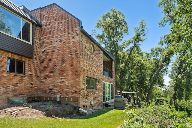 1537 N Sweetwater Ln, Farmington, UT 84025 - view of property exterior featuring brick siding, a lawn, and a balcony