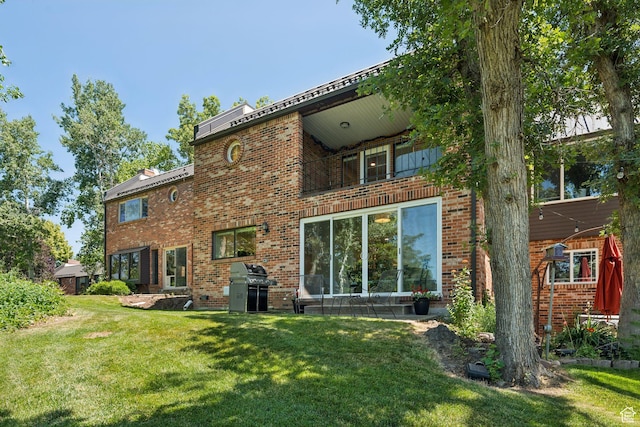 1537 N Sweetwater Ln, Farmington, UT 84025 - back of house featuring a yard, a balcony, and brick siding